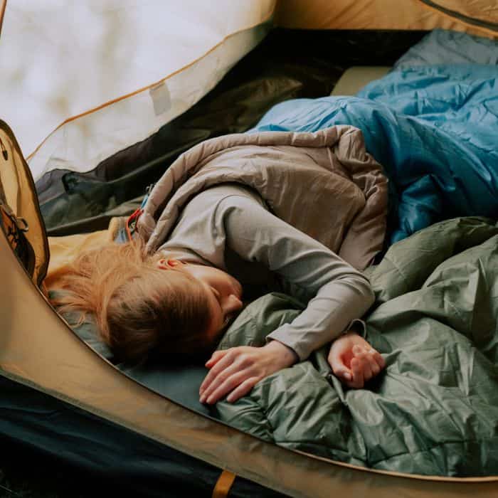 A little girl sleeping in a tent.