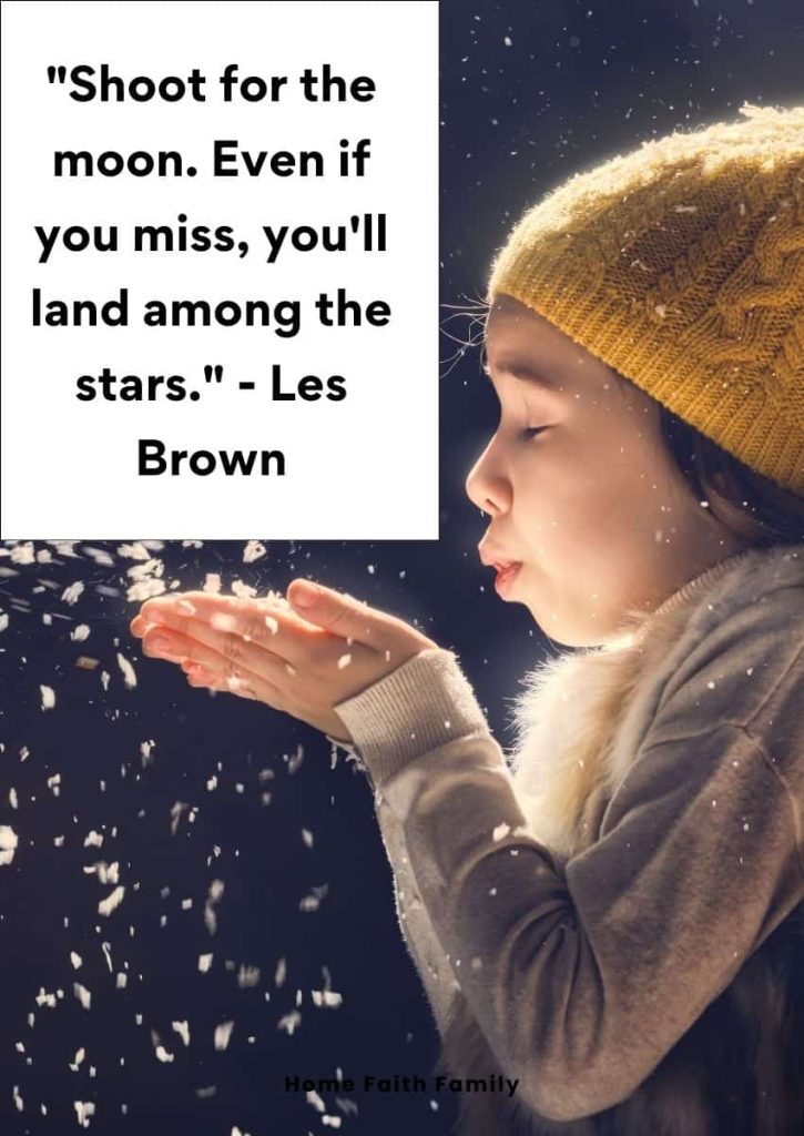 A little girl is blowing snowflakes off her hands.