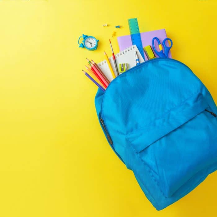Blue school backpack full of school supplies and homework.