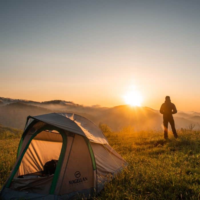 A person looking at the sunrise outside a 4-Season Tent.