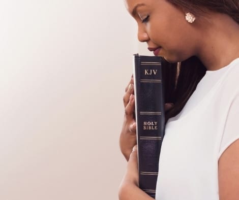 A woman praying with her Bible.