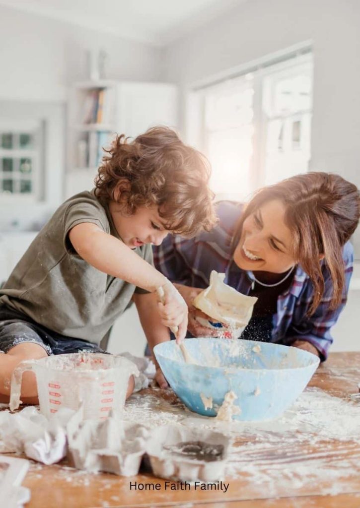A mother and son baking a dish together. The son is kneeling on the kitchen table and both are covered in flour.