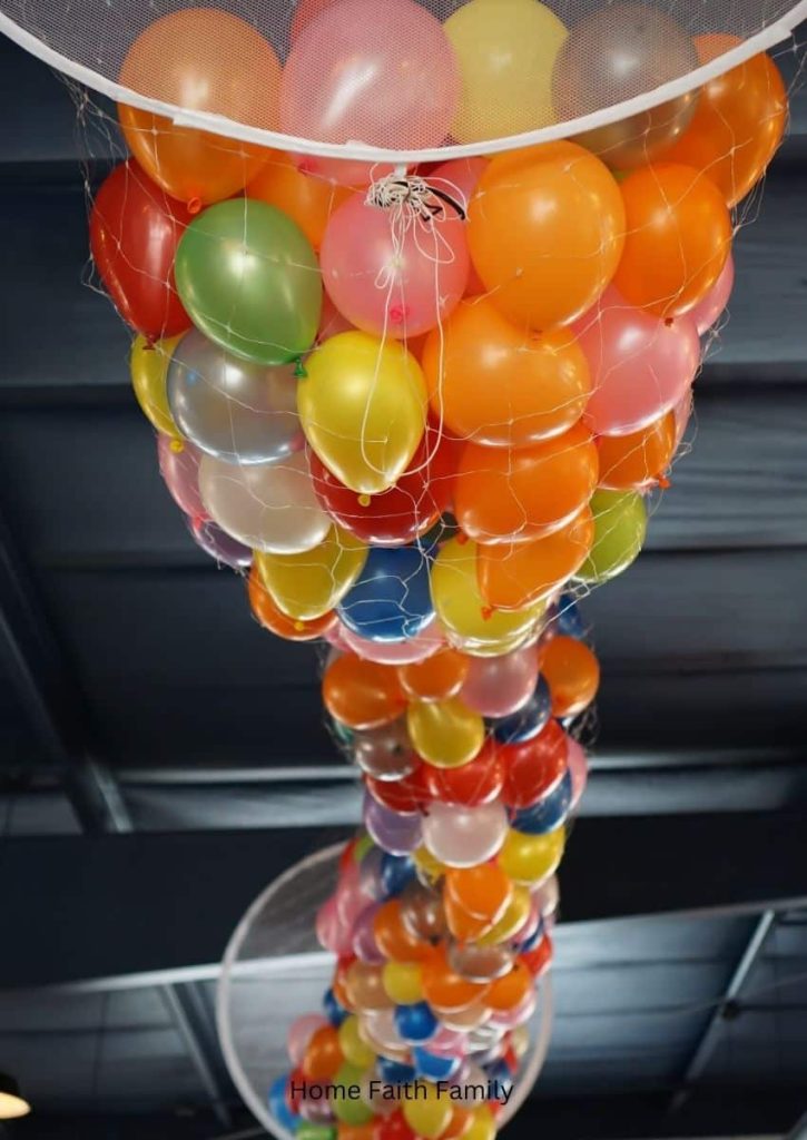 A bunch of balloons gathered together on the ceiling waiting to be dropped.