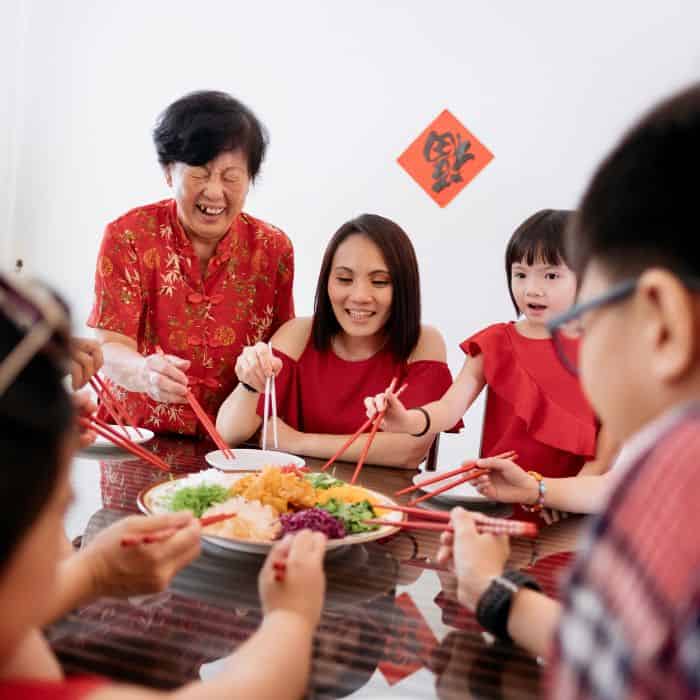 A Chinese family sitting around the dinner table celebrating the Chinese Lunar New Year.