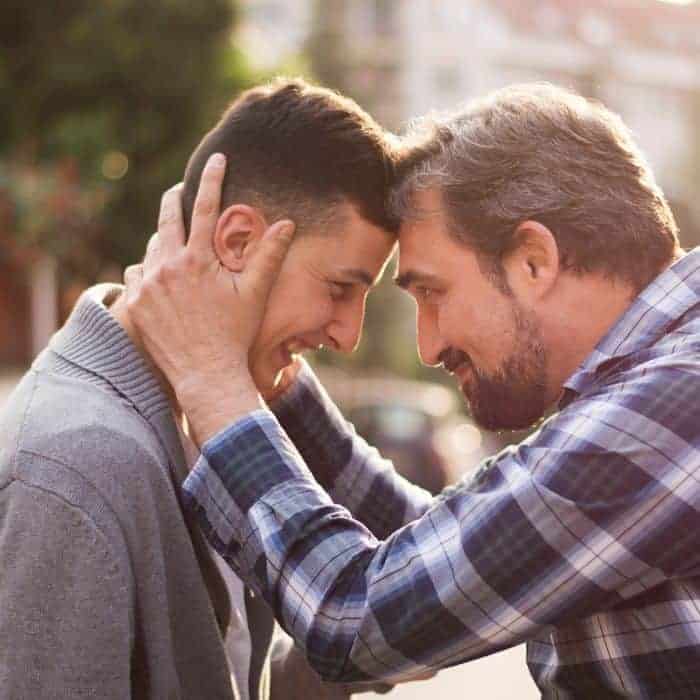 A father and son embracing.