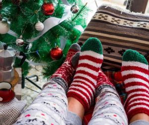 a couple of christmas socks by the christmas tree.