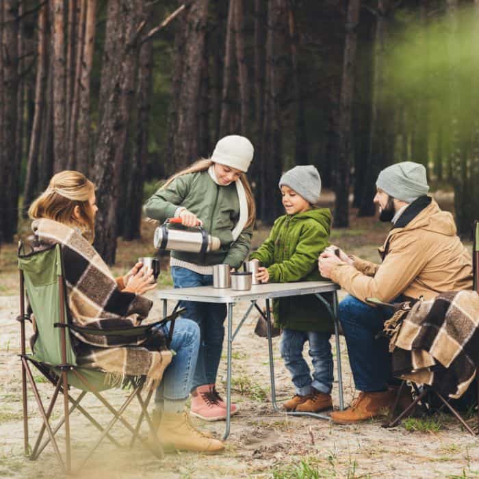 A family bundled up in warm clothes for cold weather camping.