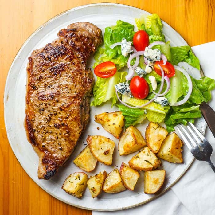 A plate of meat, salad, and potatoes. Dinner time routine for stay at home moms.