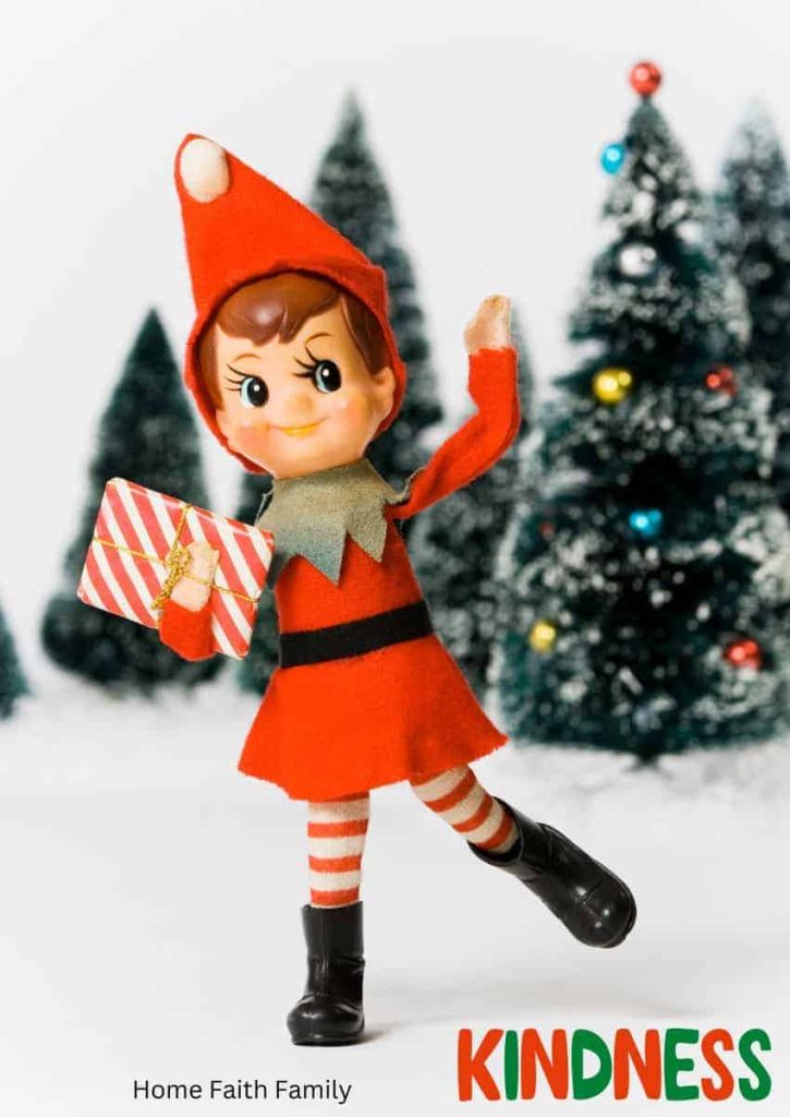 Elf on the shelf holding a present with a kindness sign.