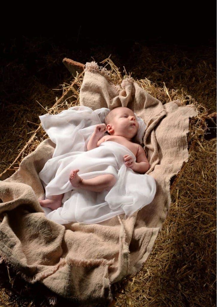 New born baby in a manger wrapped in cloth.