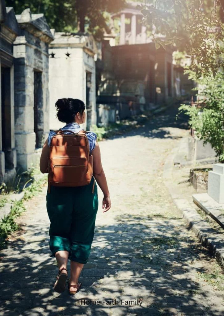 A woman walking down a city street with a brown backpack on her back.