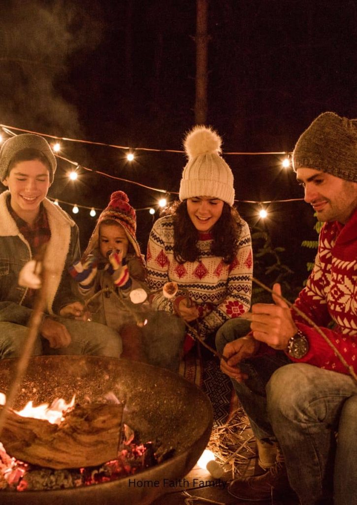 A family gathered around a camp fire at Christmas time.