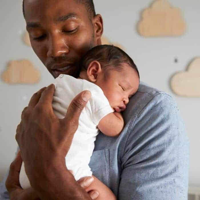 first fathers day quotes; a father cuddling a newborn baby.
