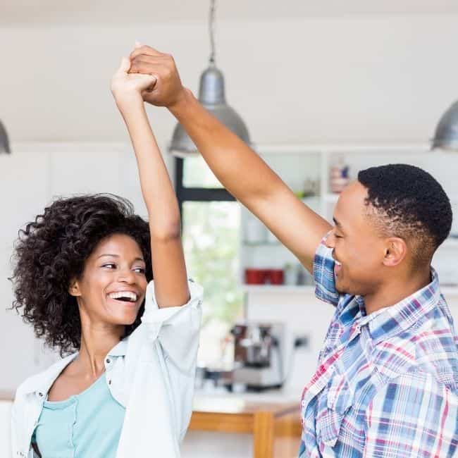 A husband and wife dancing in their home.