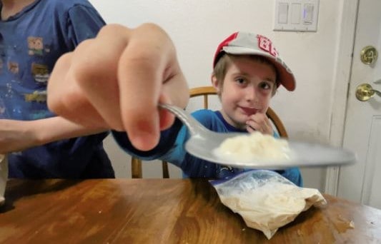 boy giving ice cream to camera.