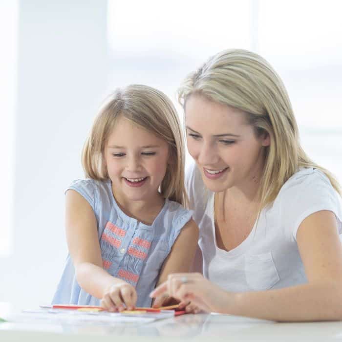 Mom teaching her daughter at home with homeschooling.