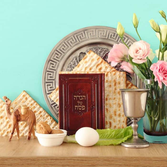 Passover symbols including scriptures, bread, egg, cup and flowers.