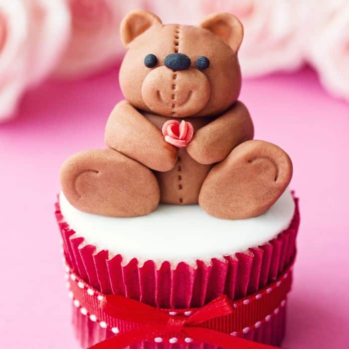 A Valentine's Day cupcake with a brown frosting bear on top.