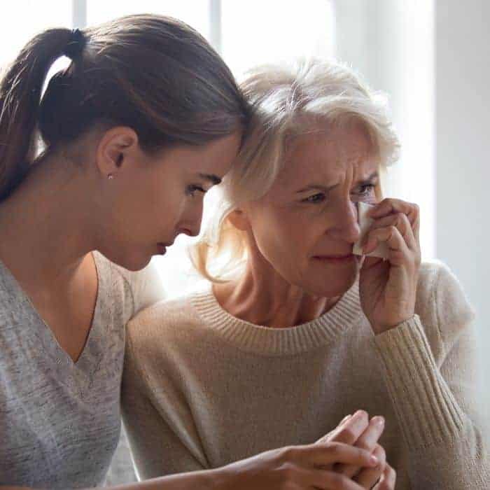 Two women mourning together.