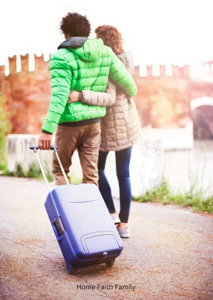 A young couple with a suitcase walking around the neighborhood. 