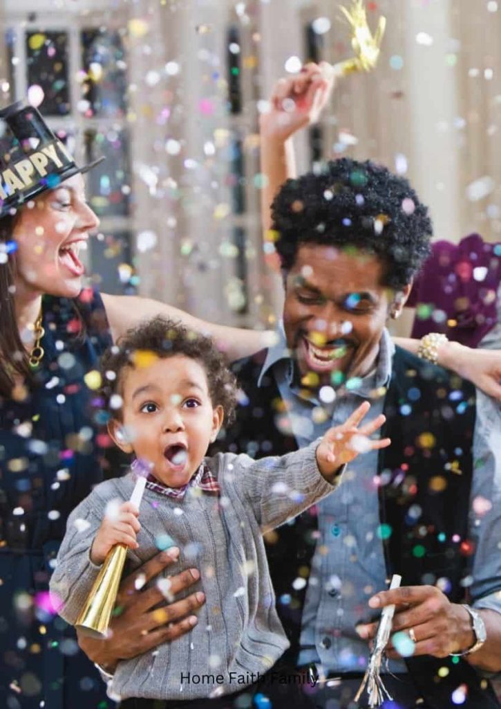 A family celebrating New Years Day and throwing confetti up into the air.