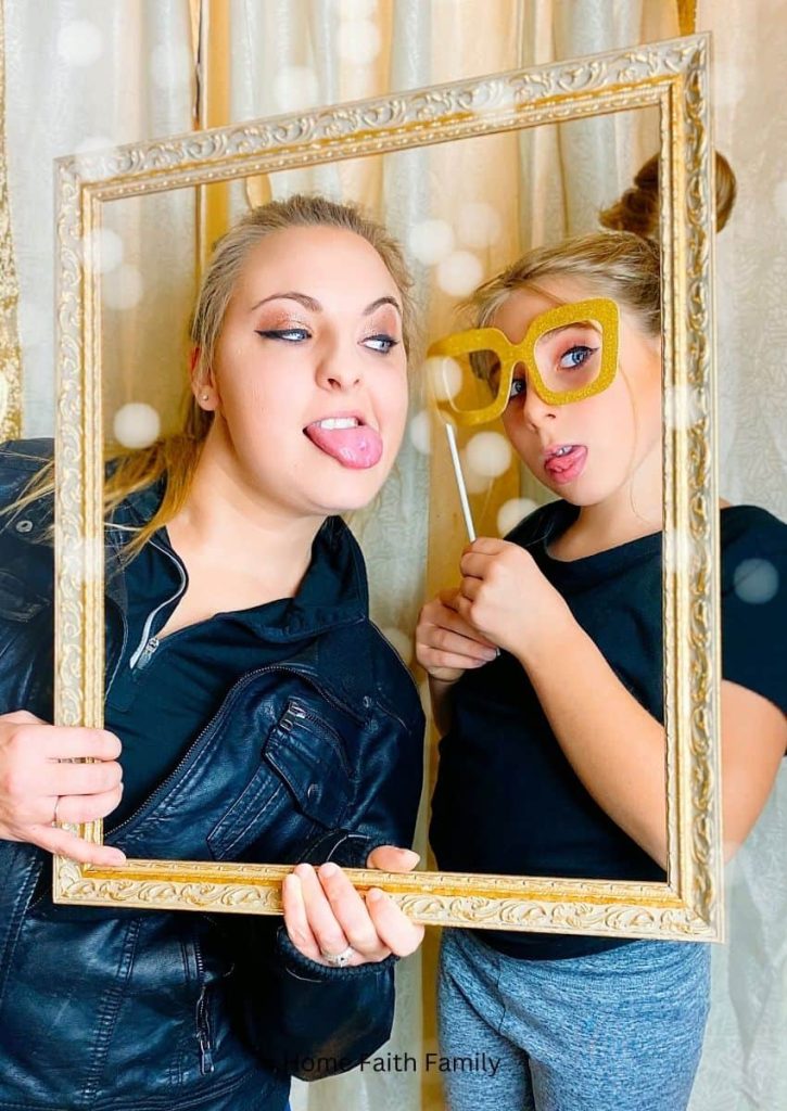 A mother and daughter with a photo booth props.