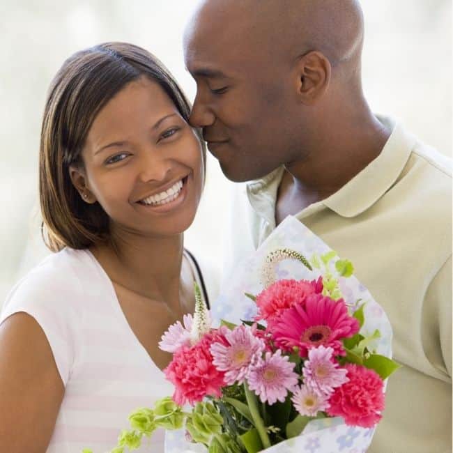 A young couple with a bouquet of flowers.