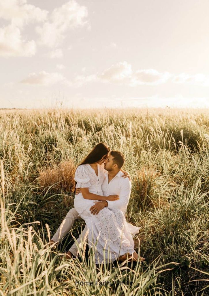 A couple sitting together in a field.