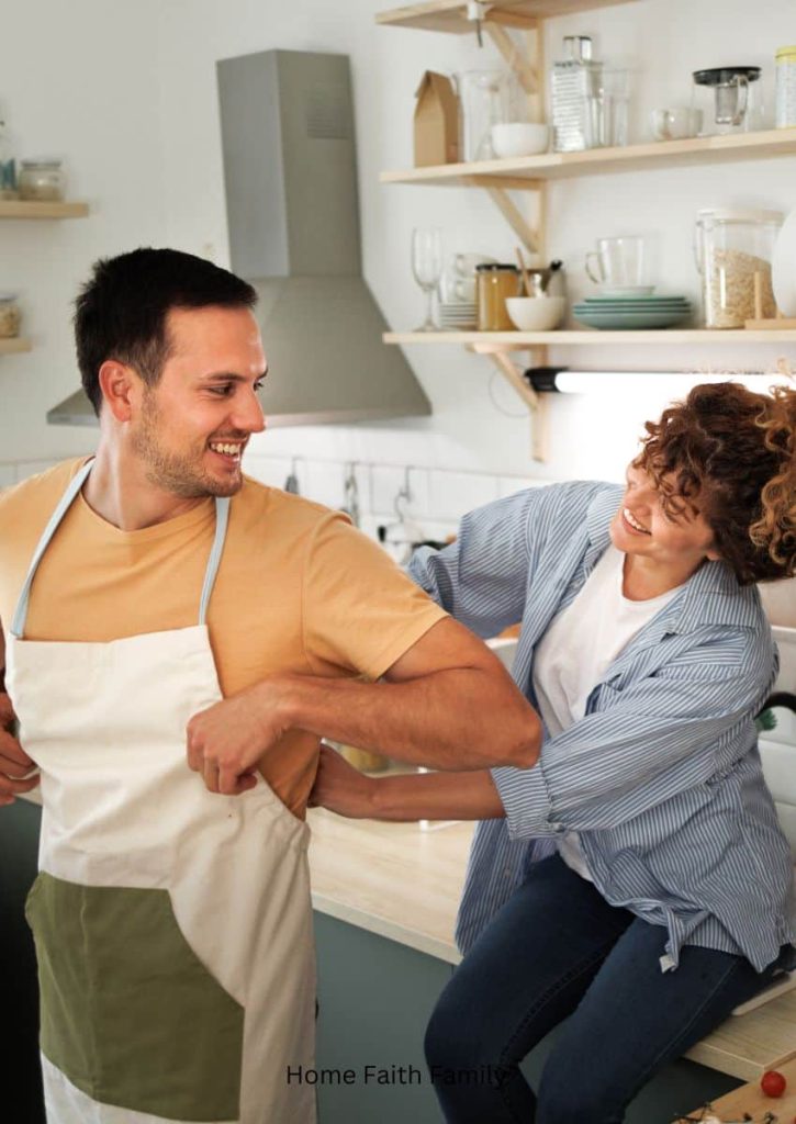A couple in the kitchen. A woman putting an apron on her husband.