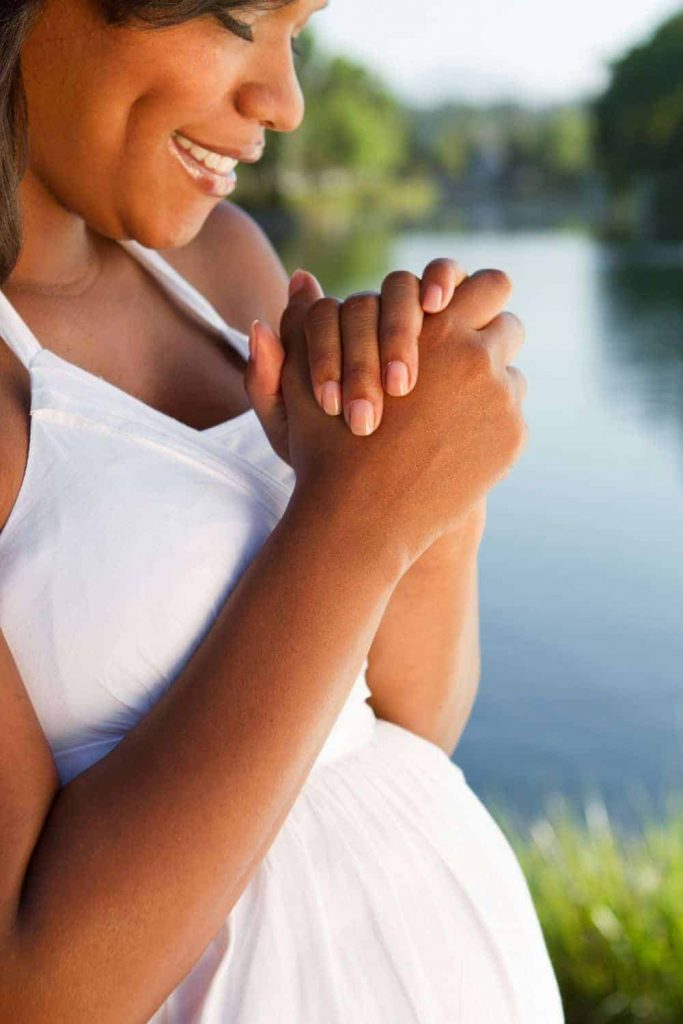 A pregnant woman praying for her unborn baby.