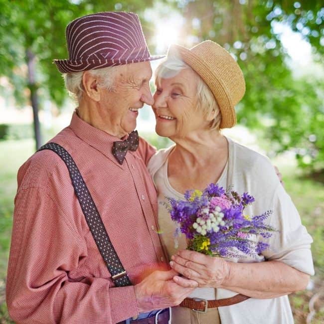 An elderly couple sharing a hug together.