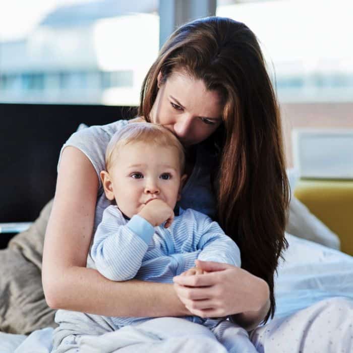 A mom holding her baby on her lap.