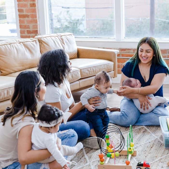 A group of moms at a playdate with their children.