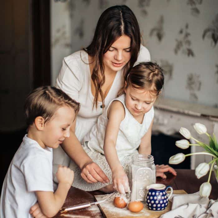 A stay at home mother working along side her son and daughter in her home.