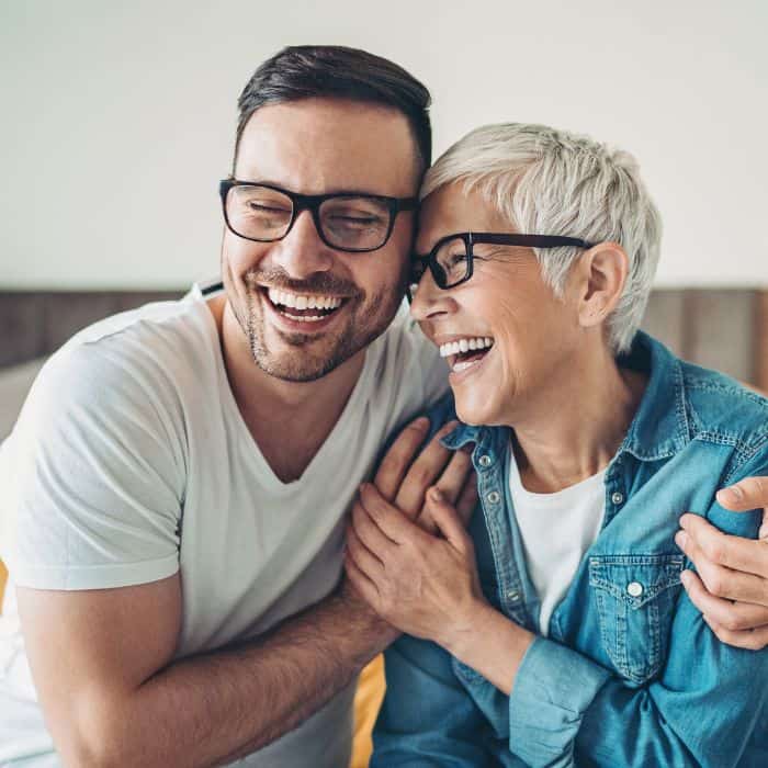 A young man embracing his elderly mother.