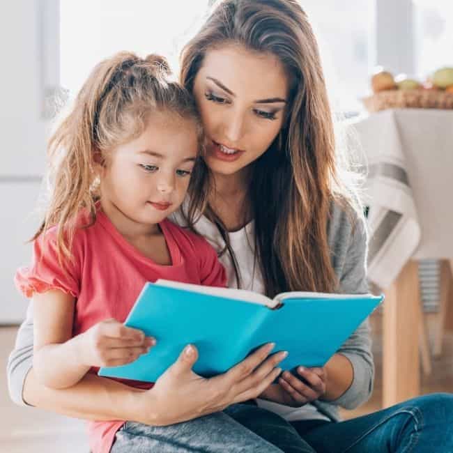 A mother and daughter reading a book together.