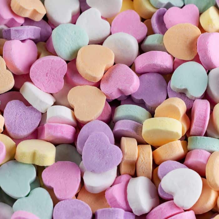 Conversation hearts in a pile.
