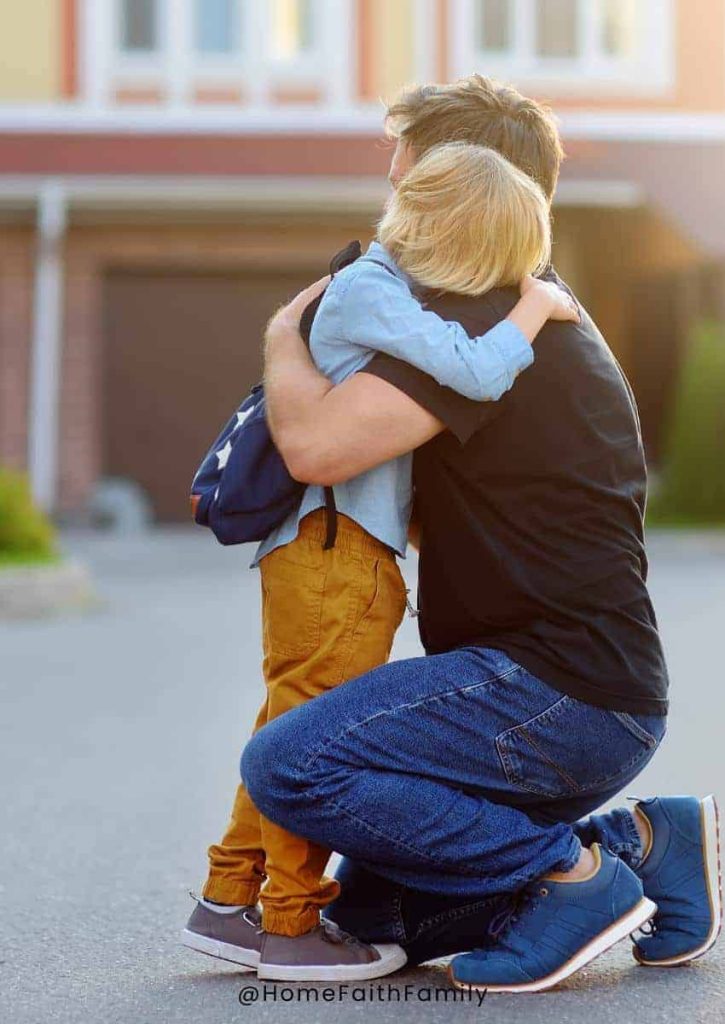 A son hugging his father in the driveway of their home.